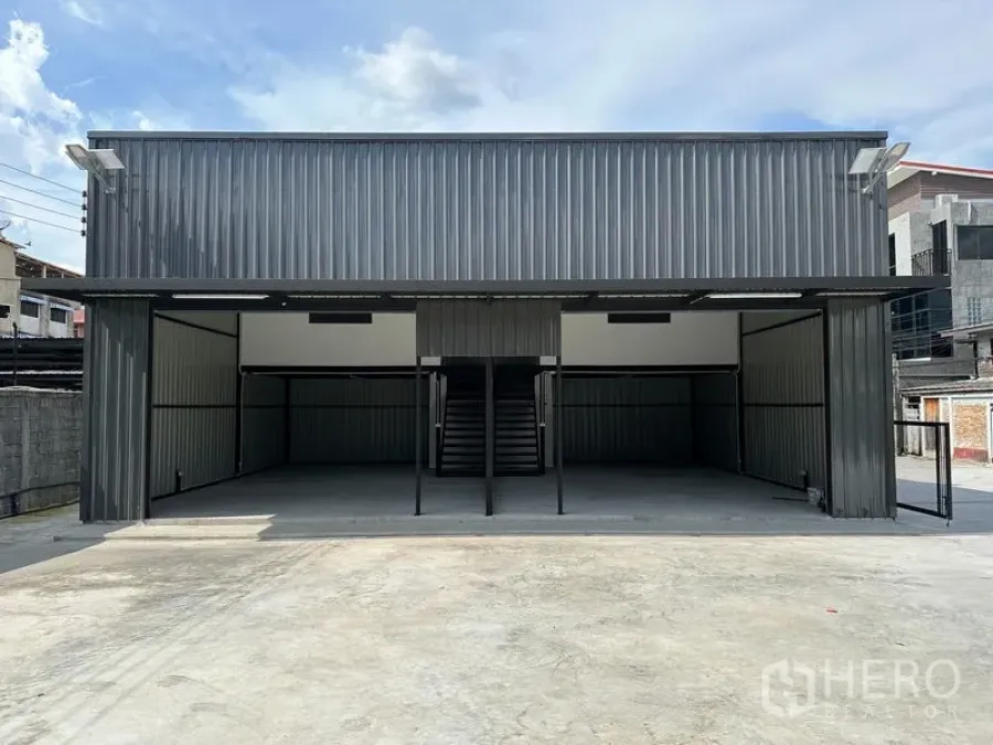 คลังสินค้า ให้เช่า - มุมมองด้านหน้าตรงของโกดัง ผนังเมทัลชีท บันไดกลาง และทางวิ่งกว้าง