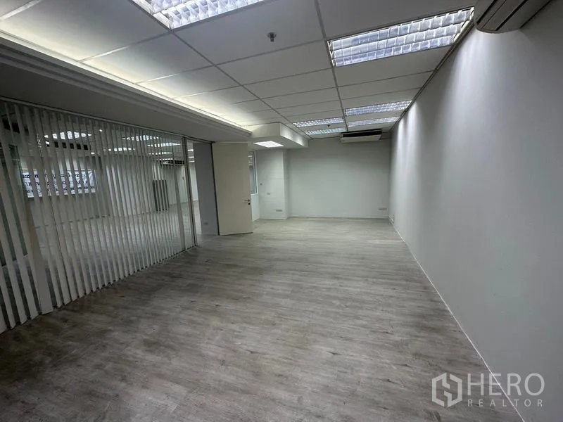 办公空间 出租在Din Daeng, Bangkok - 带竖条玻璃隔断的独立办公室，白墙与顶灯。