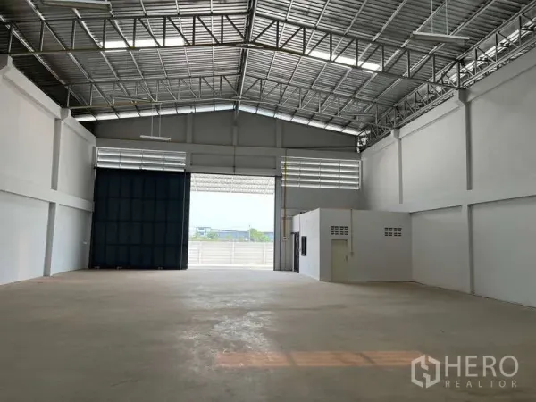 货栈 出租在Sam Phran, Nakhon Pathom - 仓库内部宽敞，钢结构大跨屋顶配采光窗，混凝土地面，宽幅卷帘门。
