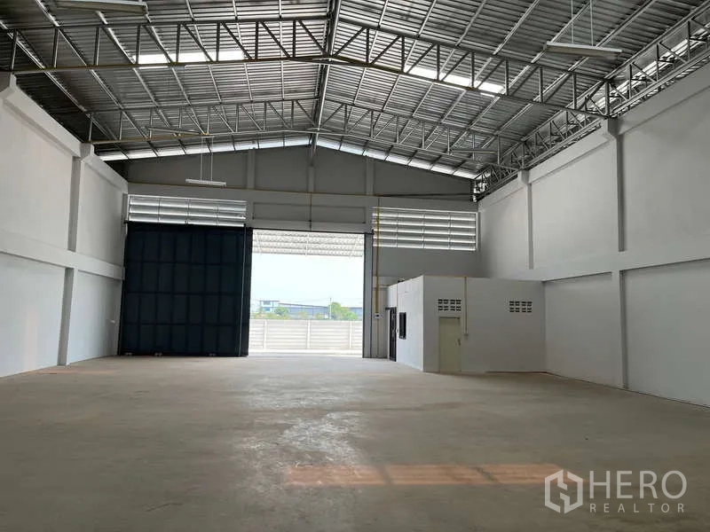 货栈 出租在Sam Phran, Nakhon Pathom - 仓库内部宽敞，钢结构大跨屋顶配采光窗，混凝土地面，宽幅卷帘门。