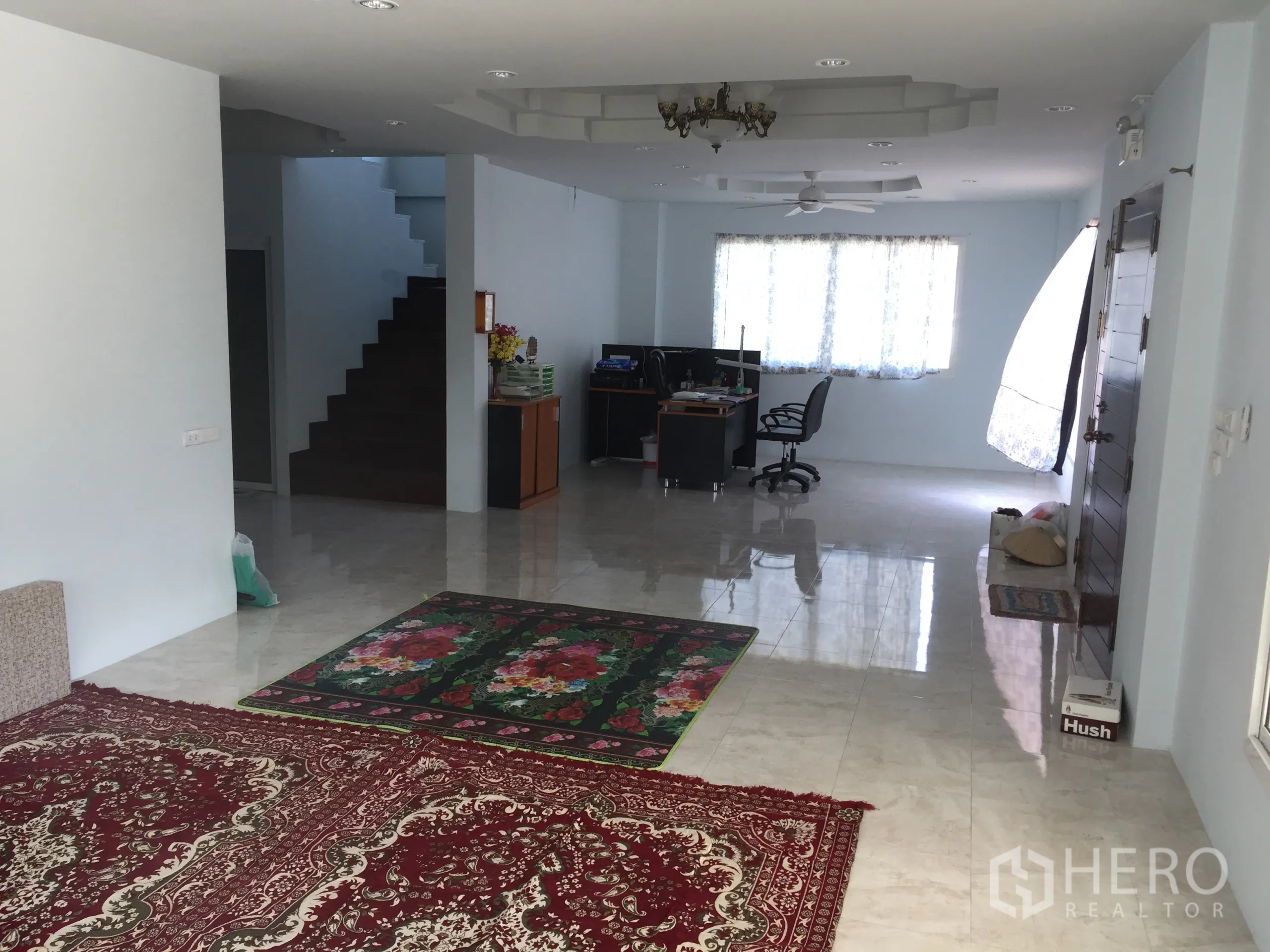独立式住宅 出租在Saphan Sung, Bangkok - 开放式客厅，亮面瓷砖地面、地毯、楼梯、办公区、窗户与吊扇。