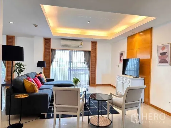 Apartment for rent - Bright living room with L-shaped sofa, recessed ceiling and sliding balcony doors.
