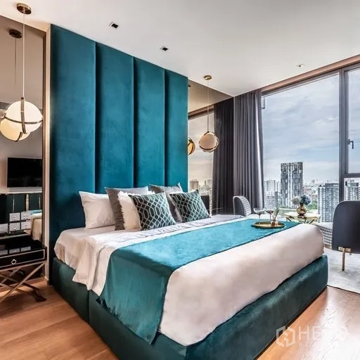 Condominium for rent in Khlong Toei, Bangkok - Another angle of the master bedroom with teal headboard, large windows and expansive Bangkok cityscape.