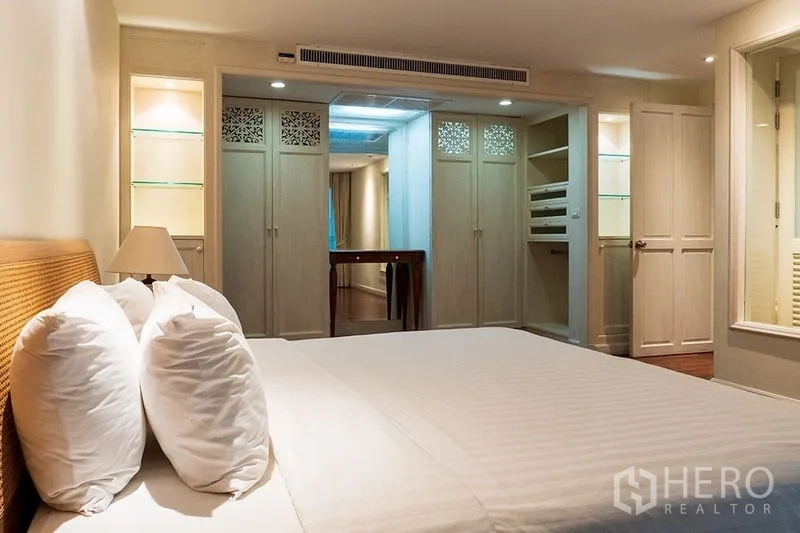 房间 出租在Bang Rak, Bangkok - 主卧配特大床、内置衣柜、更衣区，灯光柔和。