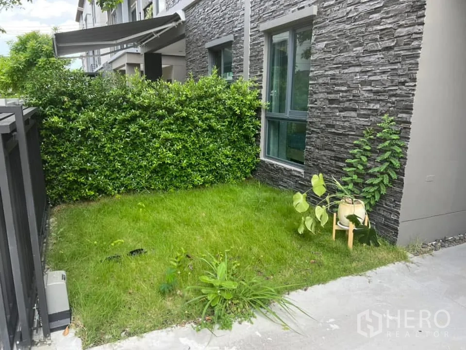 บ้านแฝด for rent in Saphan Sung, Bangkok - ภายนอกบ้านแฝดสไตล์โมเดิร์นพร้อมโรงจอดรถมีหลังคาและสนามหญ้าหน้าบ้าน
