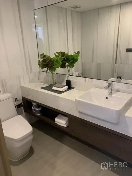 Detached House for sale in Yan Nawa, Bangkok - Stylish bathroom with large mirror, white countertop sink and built-in storage.