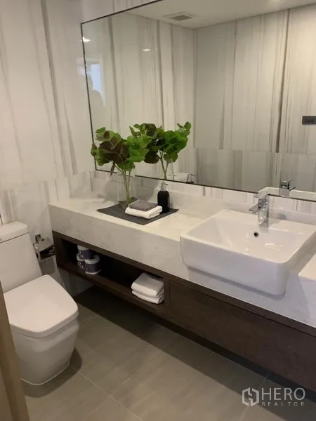 Detached House for sale in Yan Nawa, Bangkok - Stylish bathroom with large mirror, white countertop sink and built-in storage.