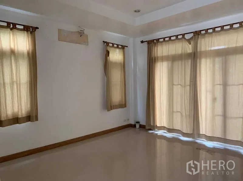 Detached House for sale in Sai Mai, Bangkok - Ground-floor living area with large windows, beige curtains and glossy tile floor.