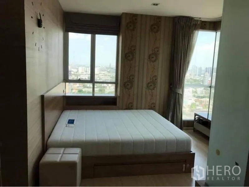 Condominium for rent or sale in Phaya Thai, Bangkok - Master bedroom with large windows, city skyline view and platform bed.
