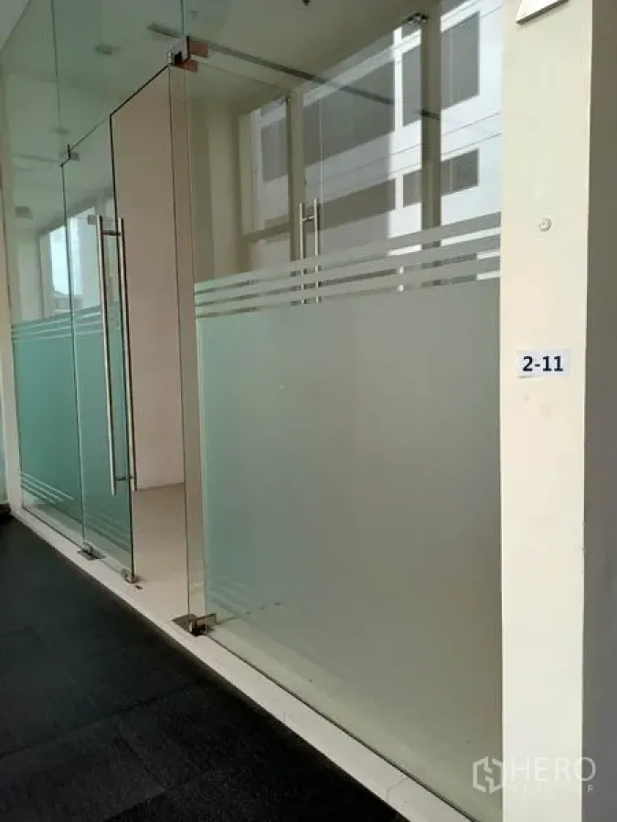 Retail Space for rent in Khlong Toei, Bangkok - Glass storefront with double doors and frosted panels along an indoor corridor.