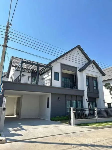 Detached House for rent in Bang Phli, Samut Prakan - Modern two-storey detached house at Centro Bangna with gated frontage, balcony and covered carport under clear sky.