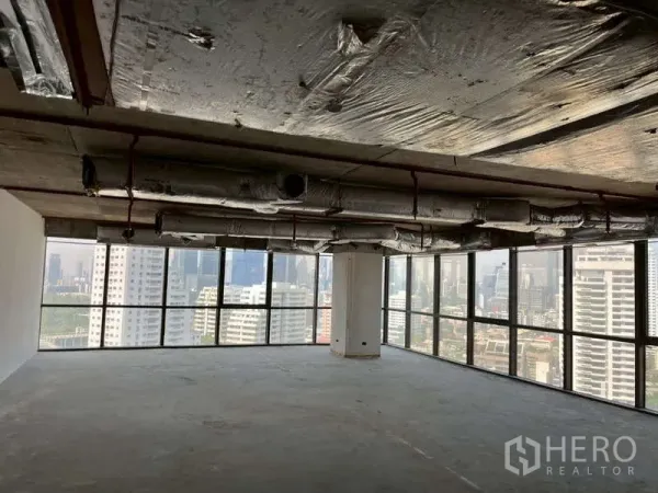 办公空间 出租 - 高楼层角落毛坯办公室，落地窗与曼谷天际线景观。