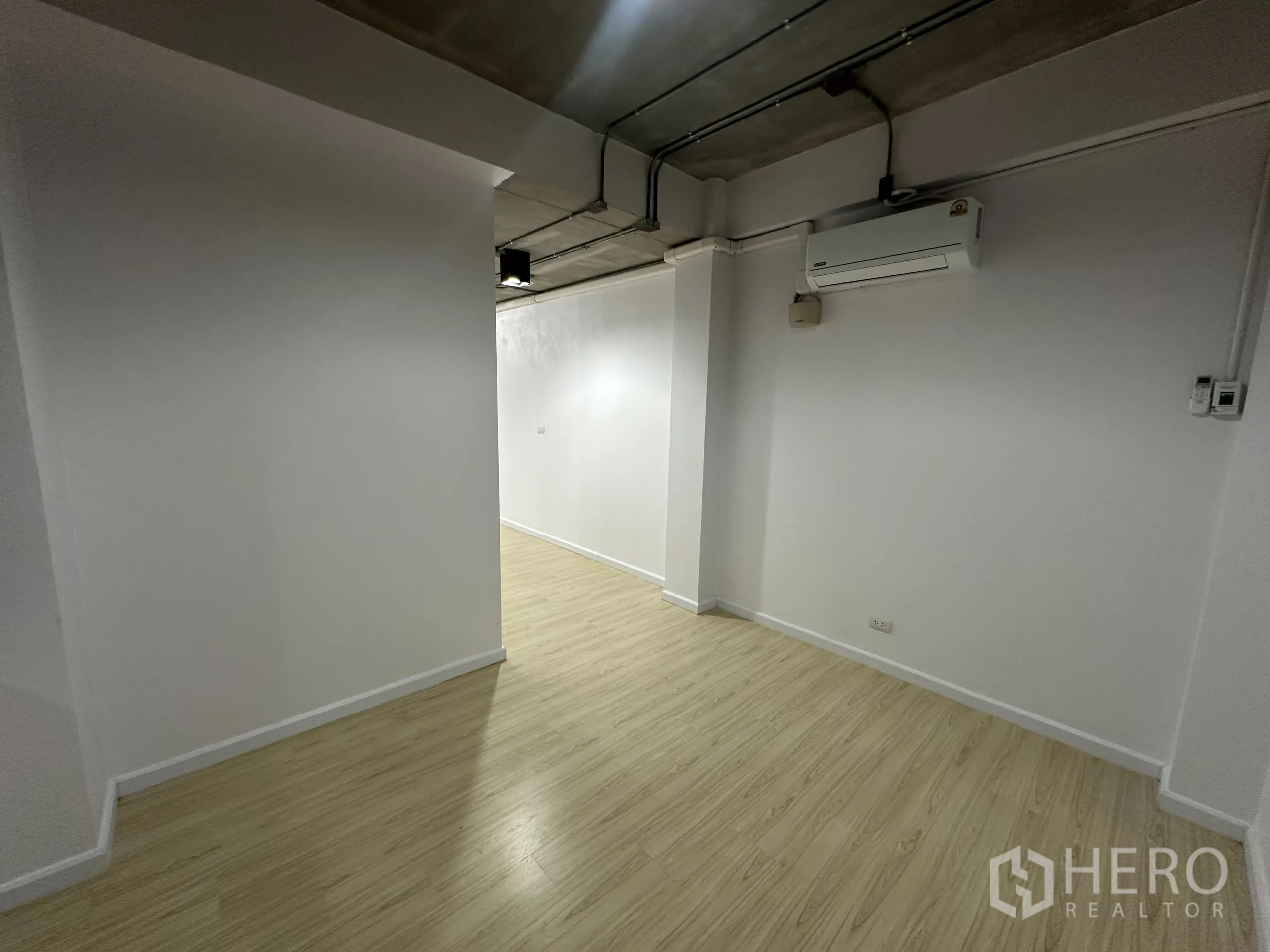 办公空间 出租在Watthana, Bangkok - 小走廊与角落，木纹地板，墙挂分体空调。