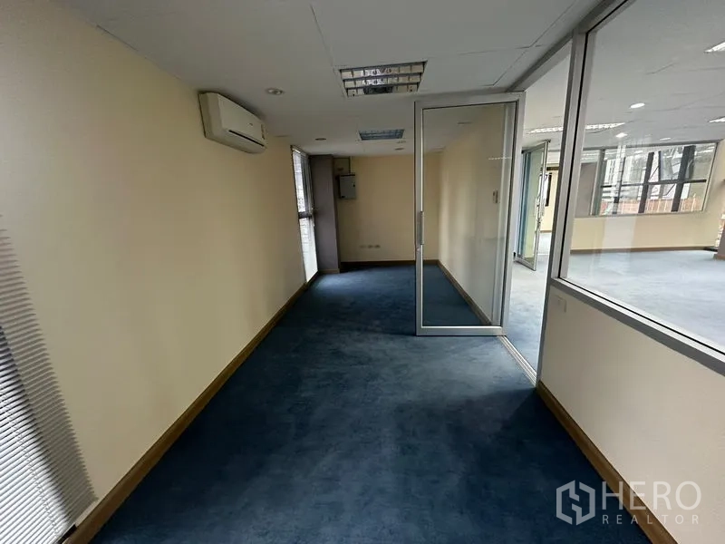 Office Space for rent in Bang Rak, Bangkok - Glass-walled meeting or manager’s room with dark carpet and wall-mounted air conditioner.