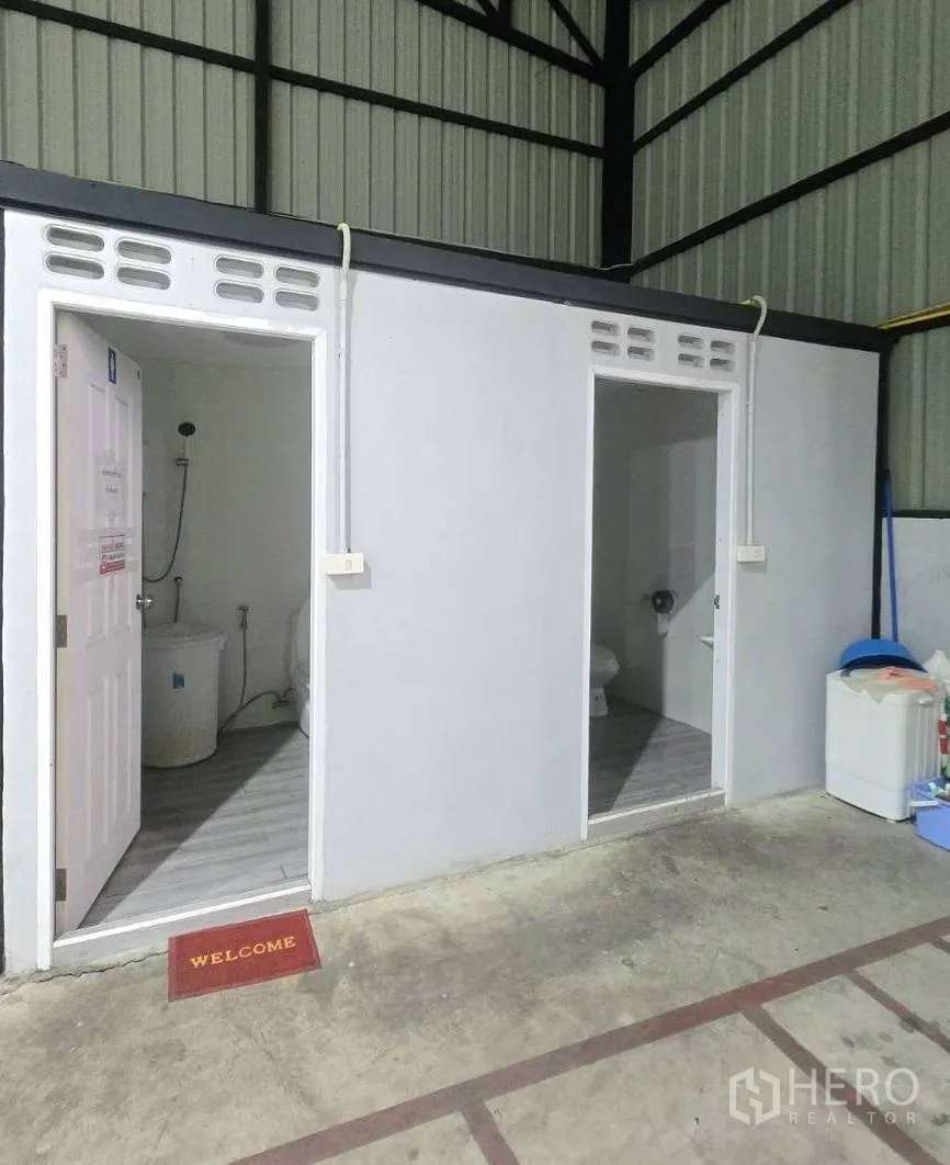 Warehouse for rent in Khlong Toei, Bangkok - Two internal restroom units built within the warehouse under the steel truss roof.