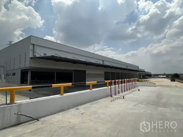 工厂 出租在Chon Buri - 现代钢结构工厂外观，长条形有顶装卸区、坡道与防护栏，位于是拉差。