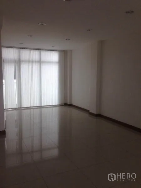 Home Office for rent in Bang Phli, Samut Prakan - Empty tiled room with white walls and vertical blinds filtering daylight.