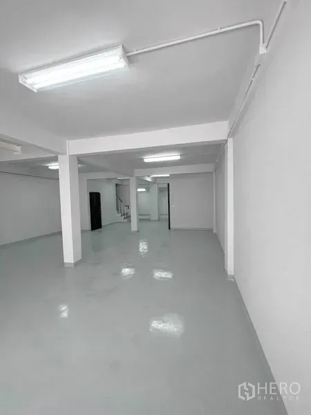 店屋 出租在Khlong Toei, Bangkok - 明亮开放的工作区，设有立柱、明线照明与室内楼梯。