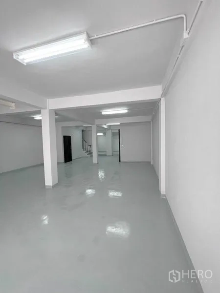 店屋 出租在Khlong Toei, Bangkok - 明亮开放的工作区，设有立柱、明线照明与室内楼梯。