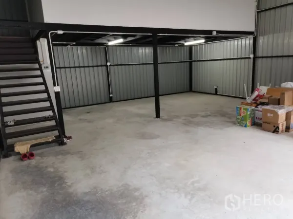仓库 for rent in Suan Luang, Bangkok - 仓库内景，混凝土地面、钢柱，左侧有通往夹层的楼梯。