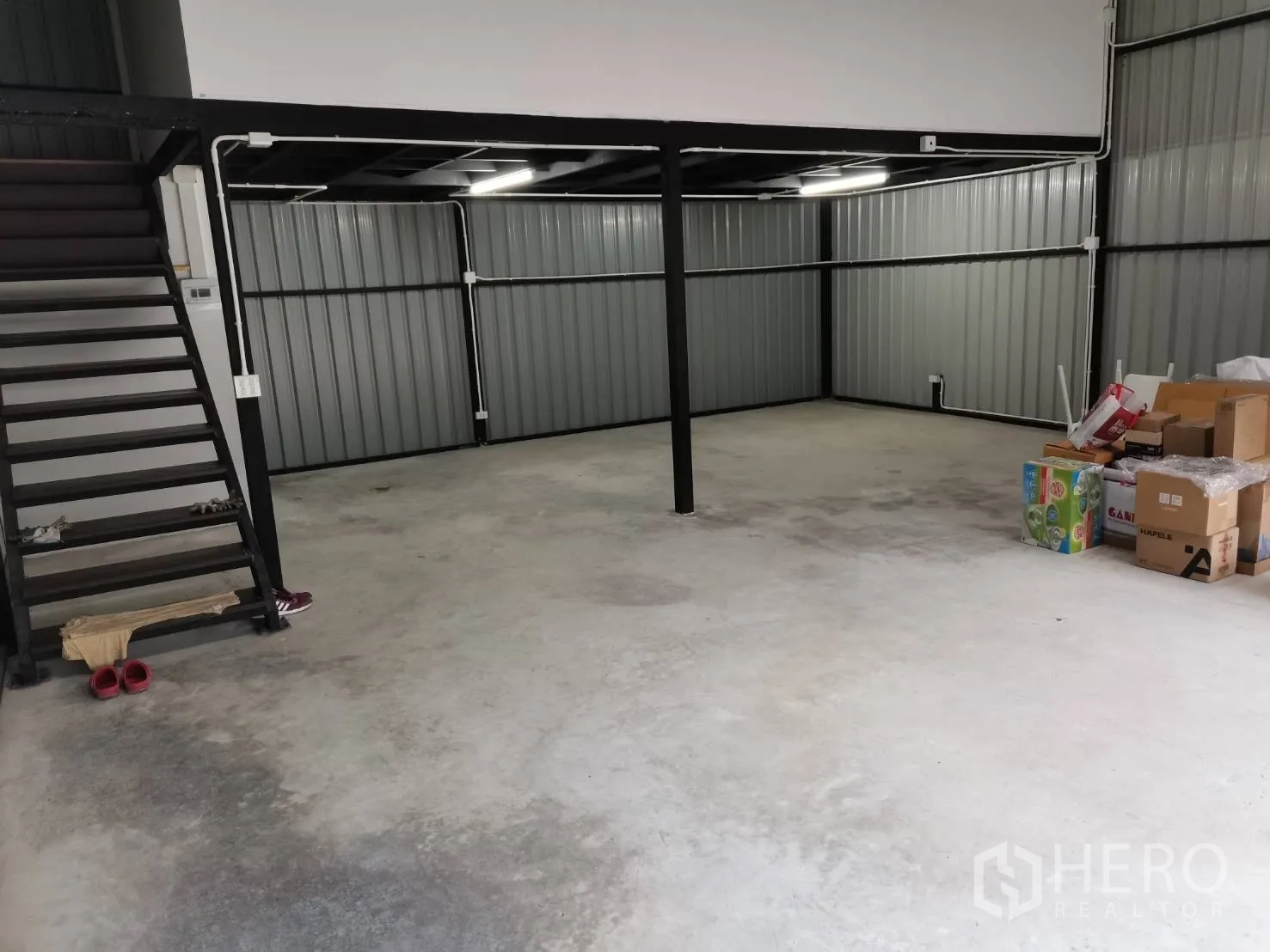 仓库 for rent in Suan Luang, Bangkok - 仓库内景，混凝土地面、钢柱，左侧有通往夹层的楼梯。