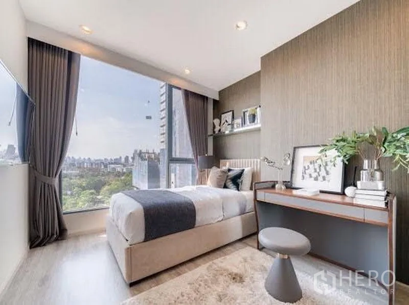 公寓 出租在Bang Na, Bangkok - 明亮次卧设书桌与单人床，落地窗可观绿意与城市景色。