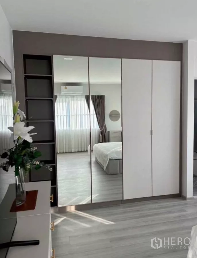 独立式住宅 出租在Bang Phli, Samut Prakan - 卧室内带镜面衣柜与开放置物架。