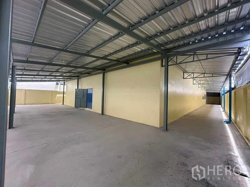 Factory for rent in Pathum Thani - Long covered side yard with metal roof suitable for storage and parking.