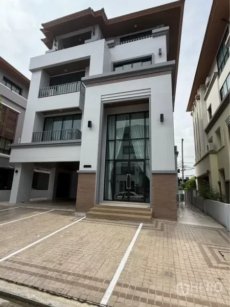 带办公室的家 出租在Wang Thonglang, Bangkok - 现代四层居家办公楼外观，超高玻璃入口与划线停车位。