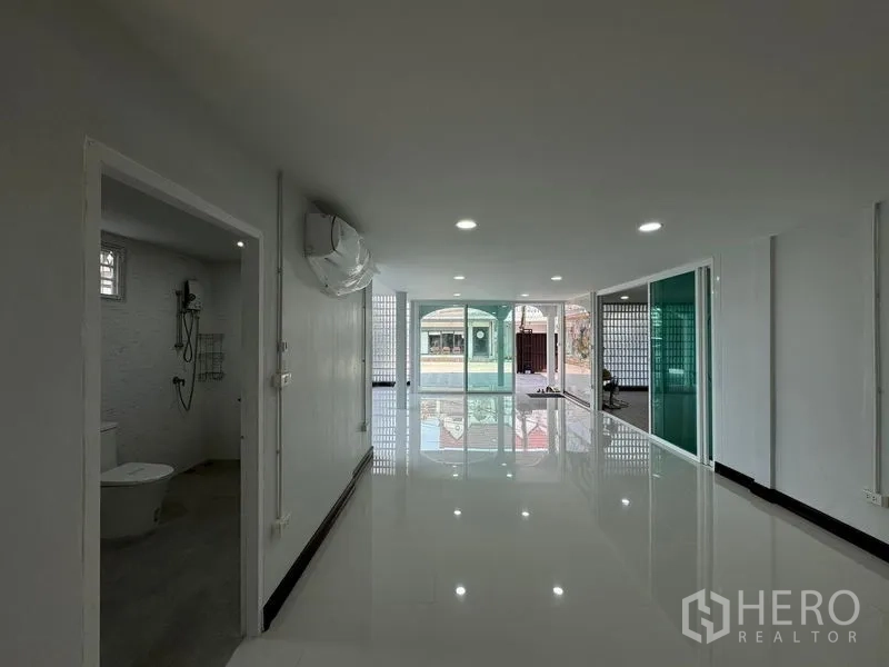 Home Office for rent in Bueng Kum, Bangkok - Ground-floor hall leading to glass front doors with bathroom entrance at left.