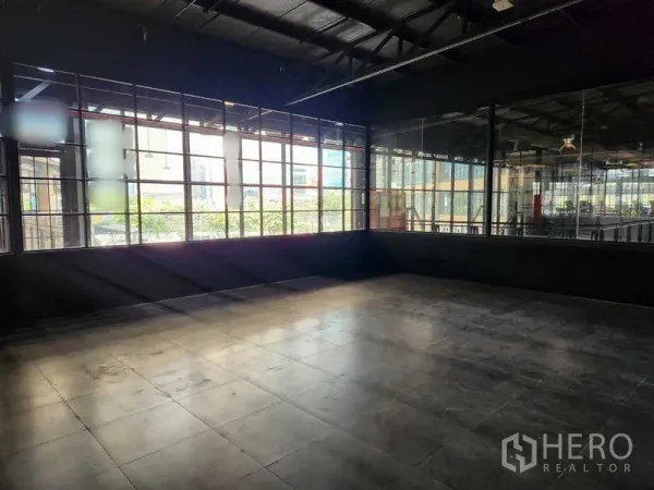Retail Space for rent in Khlong Toei, Bangkok - Loft-style retail shell with large grid windows, dark walls and tiled flooring filled with natural light.