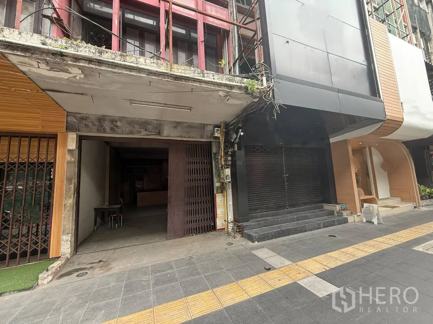Shophouse for rent in Khlong Toei, Bangkok - Street-level frontage of the shophouse beside neighboring units and a wide sidewalk.