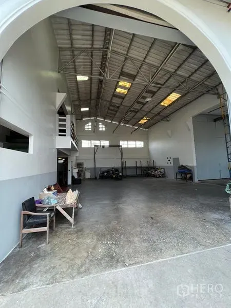 货栈 出租在Thung Khru, Bangkok - 高挑仓库内景，钢结构屋顶，夹层办公室与开阔混凝土地面。