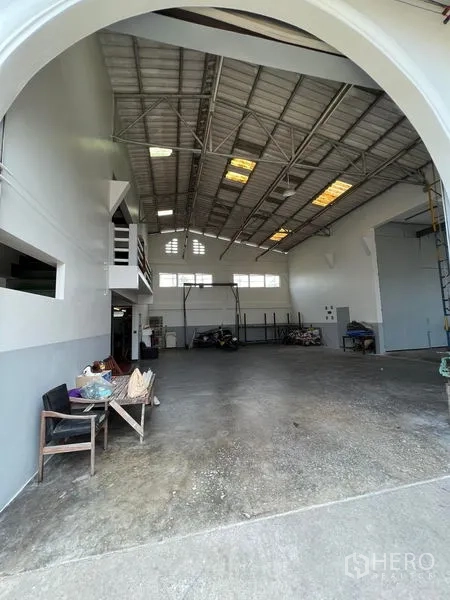 货栈 出租在Thung Khru, Bangkok - 高挑仓库内景，钢结构屋顶，夹层办公室与开阔混凝土地面。