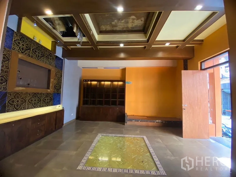 Retail Space for rent in Watthana, Bangkok - Front room featuring a coffered ceiling, built-in display shelves, and bright accent walls.