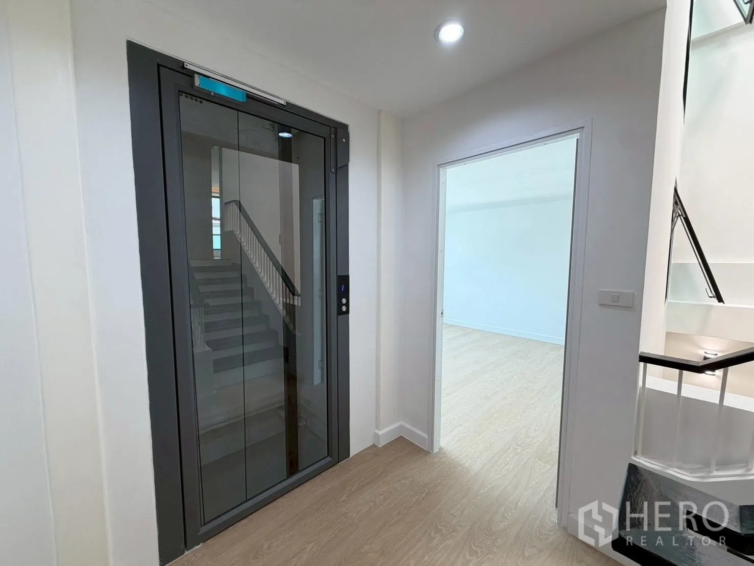 Townhouse for sale in Phra Khanong, Bangkok - Private home elevator beside a staircase in a clean hallway.