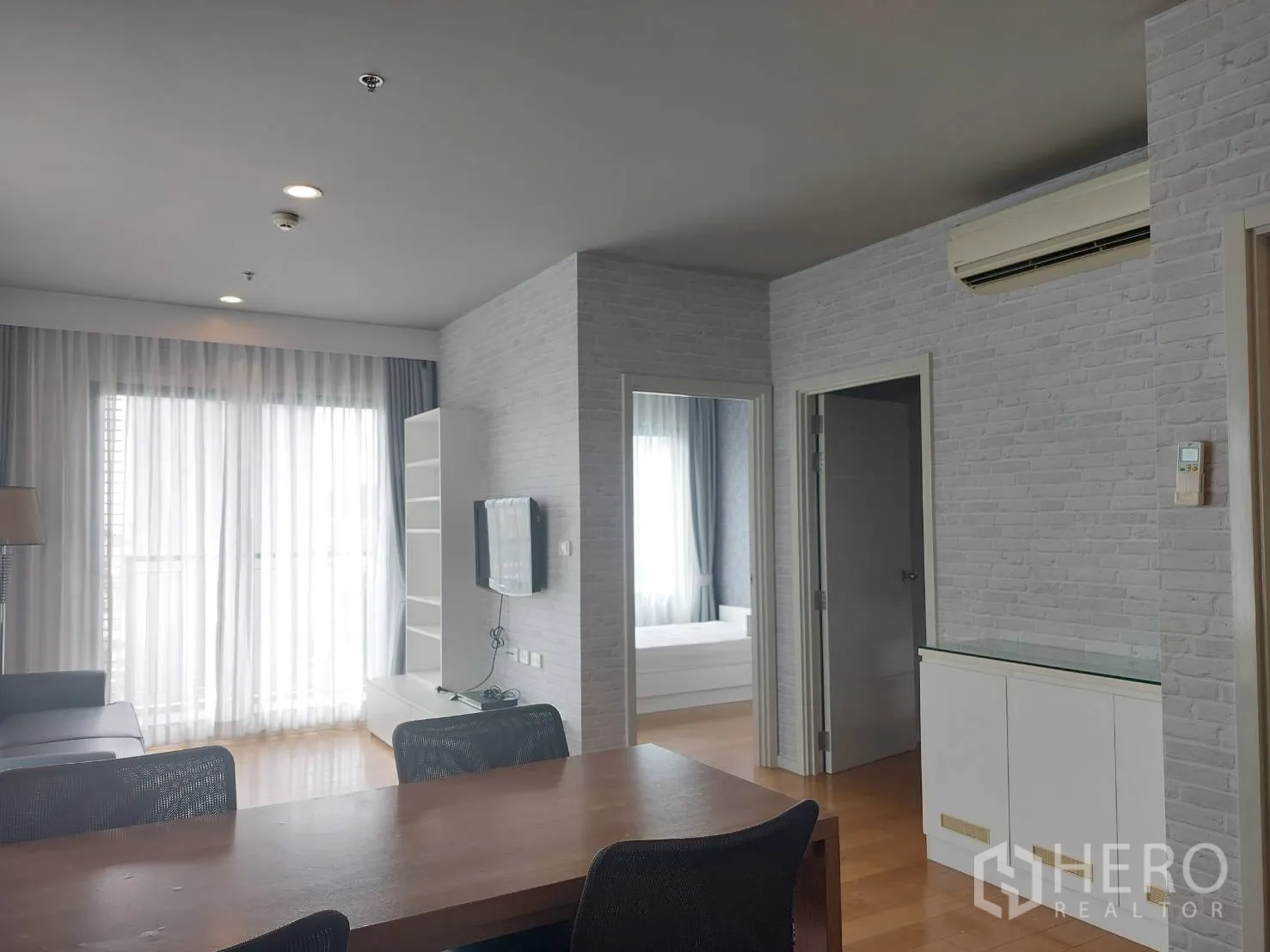 公寓 出租在Watthana, Bangkok - 开放式餐客一体空间，纱帘与木地板通向卧室