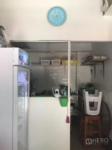 零售空间 出租在Watthana, Bangkok - 室内备餐区，含操作台、冰箱、置物架与白色瓷砖墙。
