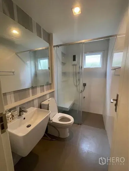 Detached House for rent in Lat Krabang, Bangkok - Compact bathroom with glass-enclosed shower, sink, mirror and toilet