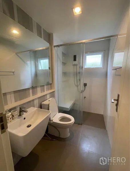 Detached House for rent in Lat Krabang, Bangkok - Compact bathroom with glass-enclosed shower, sink, mirror and toilet