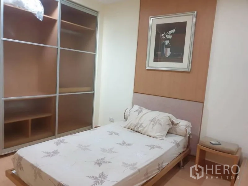 Condominium for rent in Watthana, Bangkok - Cozy second bedroom with built-in sliding wardrobe and bedside table.