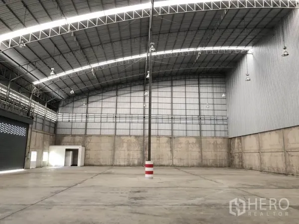 Warehouse for rent in Lam Luk Ka, Pathum Thani - Spacious warehouse interior featuring a high arched steel roof and smooth concrete floor.