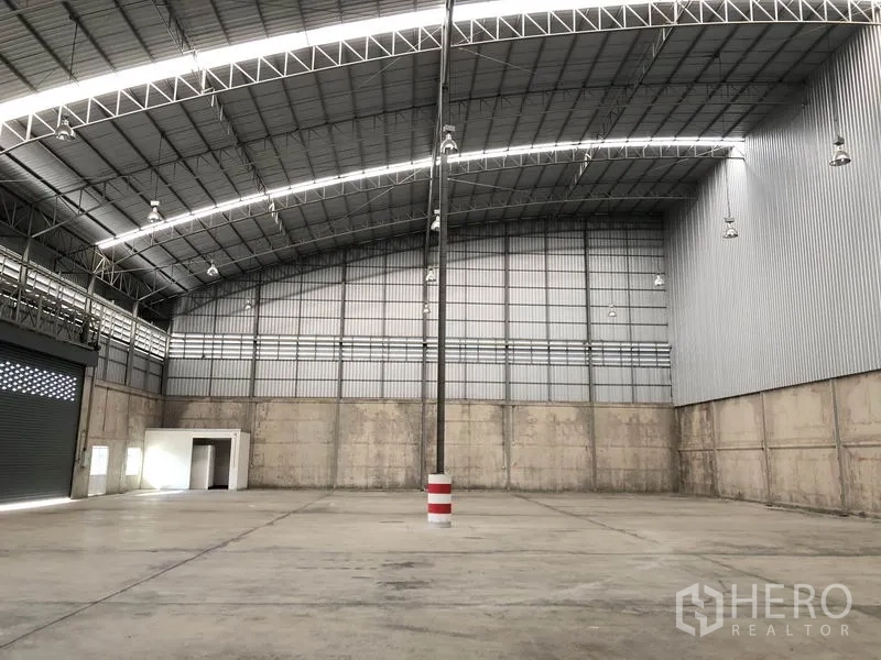 Warehouse for rent in Lam Luk Ka, Pathum Thani - Spacious warehouse interior featuring a high arched steel roof and smooth concrete floor.