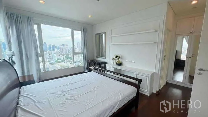 คอนโด ให้เช่าในWatthana, Bangkok - ห้องนอนพร้อมชั้นวางติดผนัง โต๊ะ และทางเข้าห้องแต่งตัว