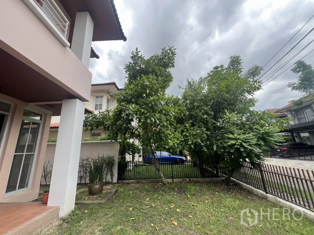 Detached House for rent in Wang Thonglang, Bangkok - Side view of the house with covered terrace and small landscaped yard.