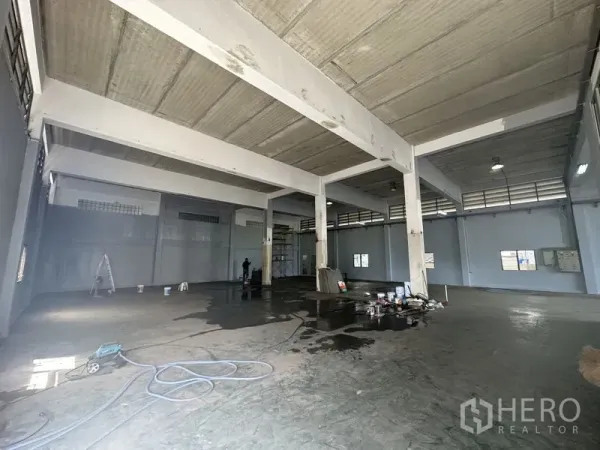 Factory for rent or sale in Bang Bua Thong, Nonthaburi - Open warehouse space with multiple columns, industrial lighting and ventilated upper windows.
