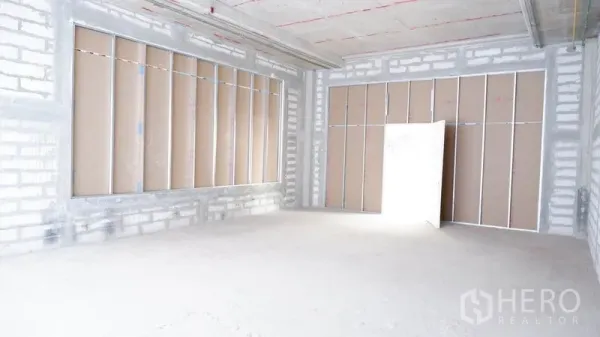 Retail Space for rent in Khlong Toei, Bangkok - Bright open-plan room with framed partitions and a high ceiling in bare-shell condition.