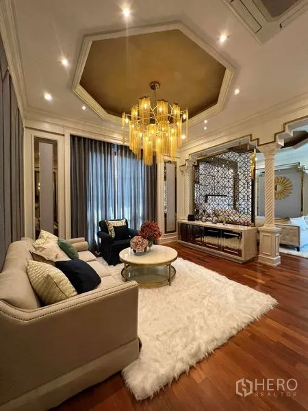 独立式住宅 出租或出售在Thawi Watthana, Bangkok - 套房起居区，金色吊灯与隔断后的卧室。