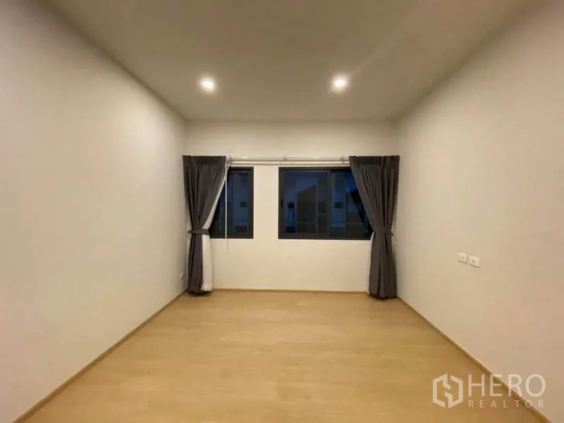 联排别墅 出租在Prawet, Bangkok - 宽敞卧室，三扇窗户搭配遮光窗帘。