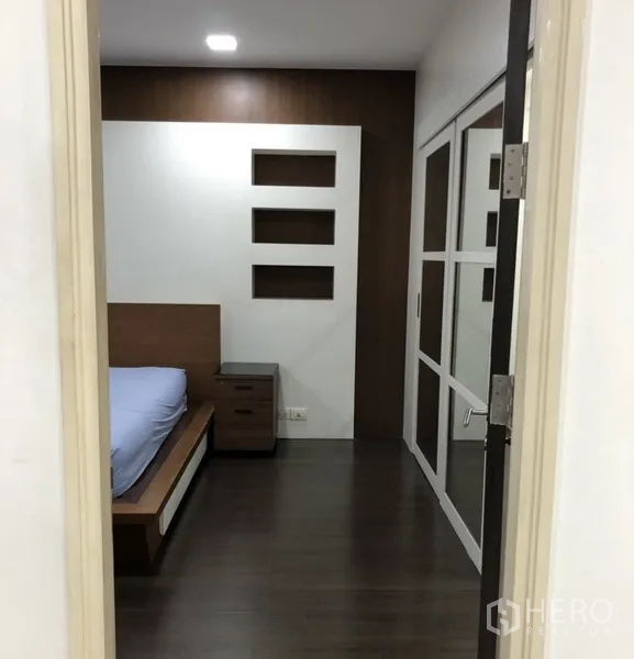 公寓 出租在Khlong Toei, Bangkok - 卧室入口可见内置壁龛、床头柜与推拉衣柜门。